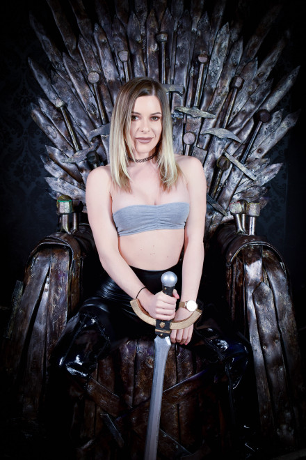 Marni Moore in PVC mini dress and thigh high boots on the Iron Throne. Marni Moore in PVC mini dress and thigh high boots on the Iron Throne.
